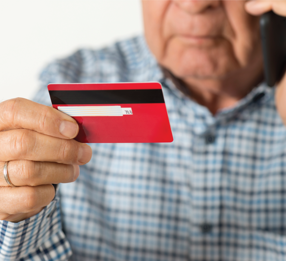 Senior holding a credit card and talking on the phone